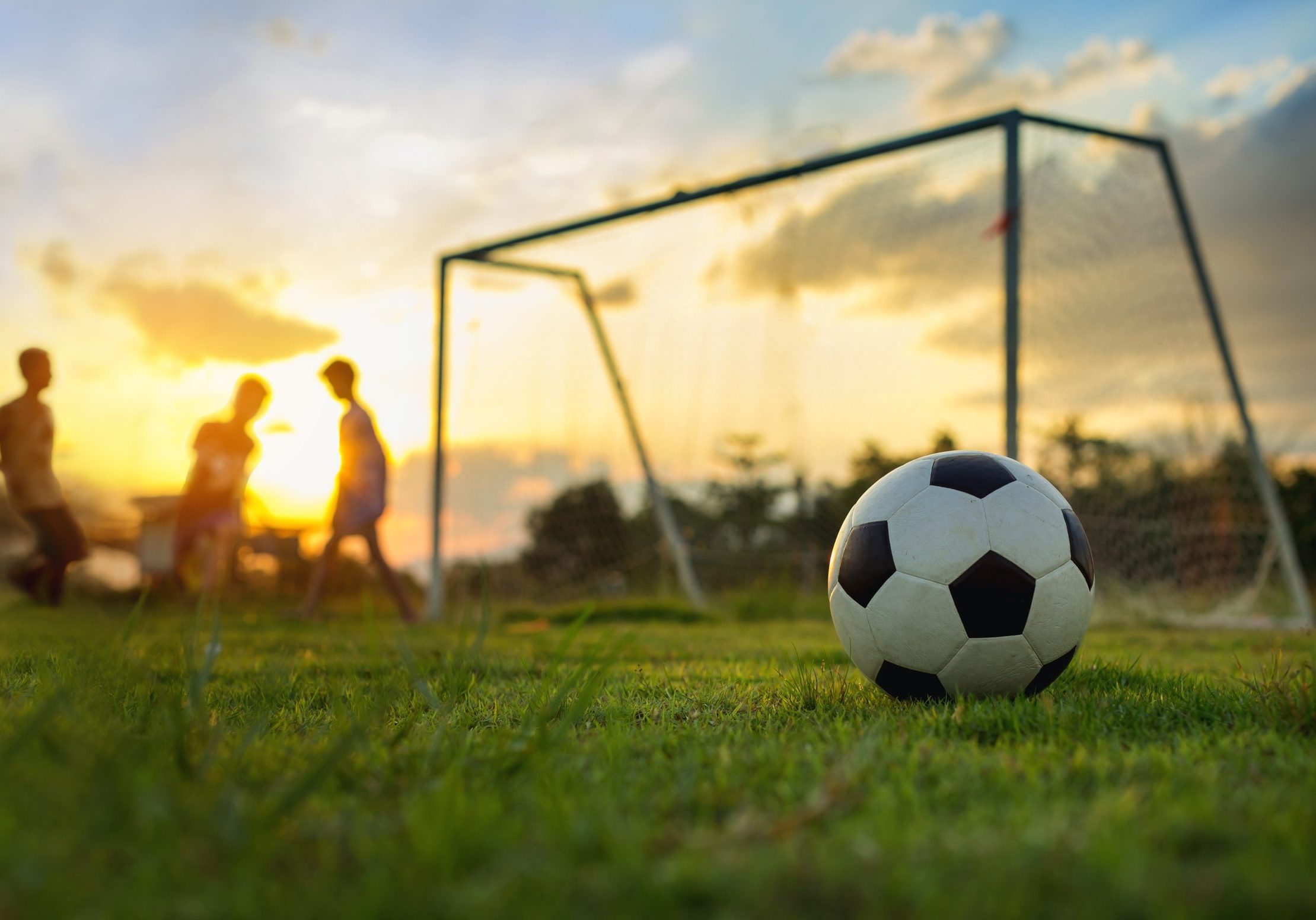 Silhouette action picture of a group of kids playing soccer foot